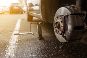 A car jacked up with the tire removed while replacing a tire.