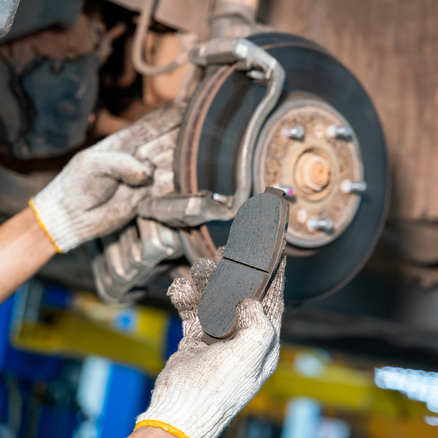 Car mechanic repairing brakes on car in auto repair service center