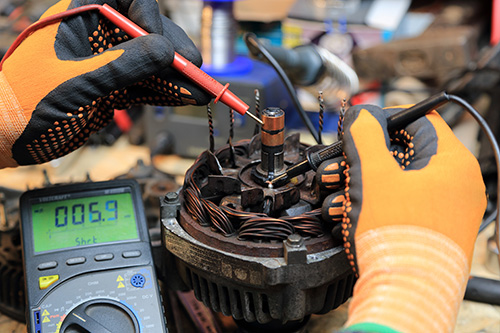 A person testing the electrical output of a car.