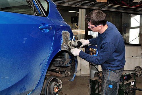 A repair shop working on the body of a car.